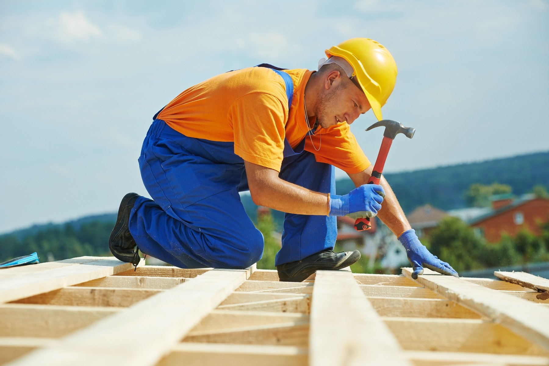 Construction couvreur ouvrier charpentier cloue planche de bois avec un marteau sur les travaux d'installation toit plat
