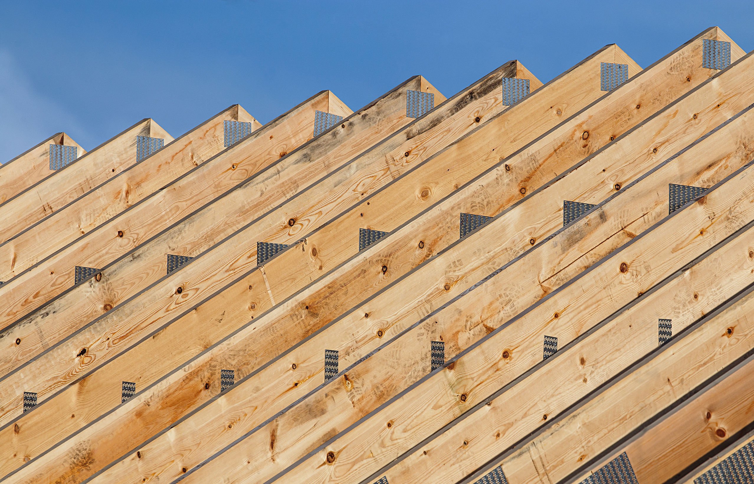 Prix charpente en kit pour maison, Rangée de fermes de toit en bois dans une ligne sur une construction de toit moderne d'un nouvel entrepôt de construction